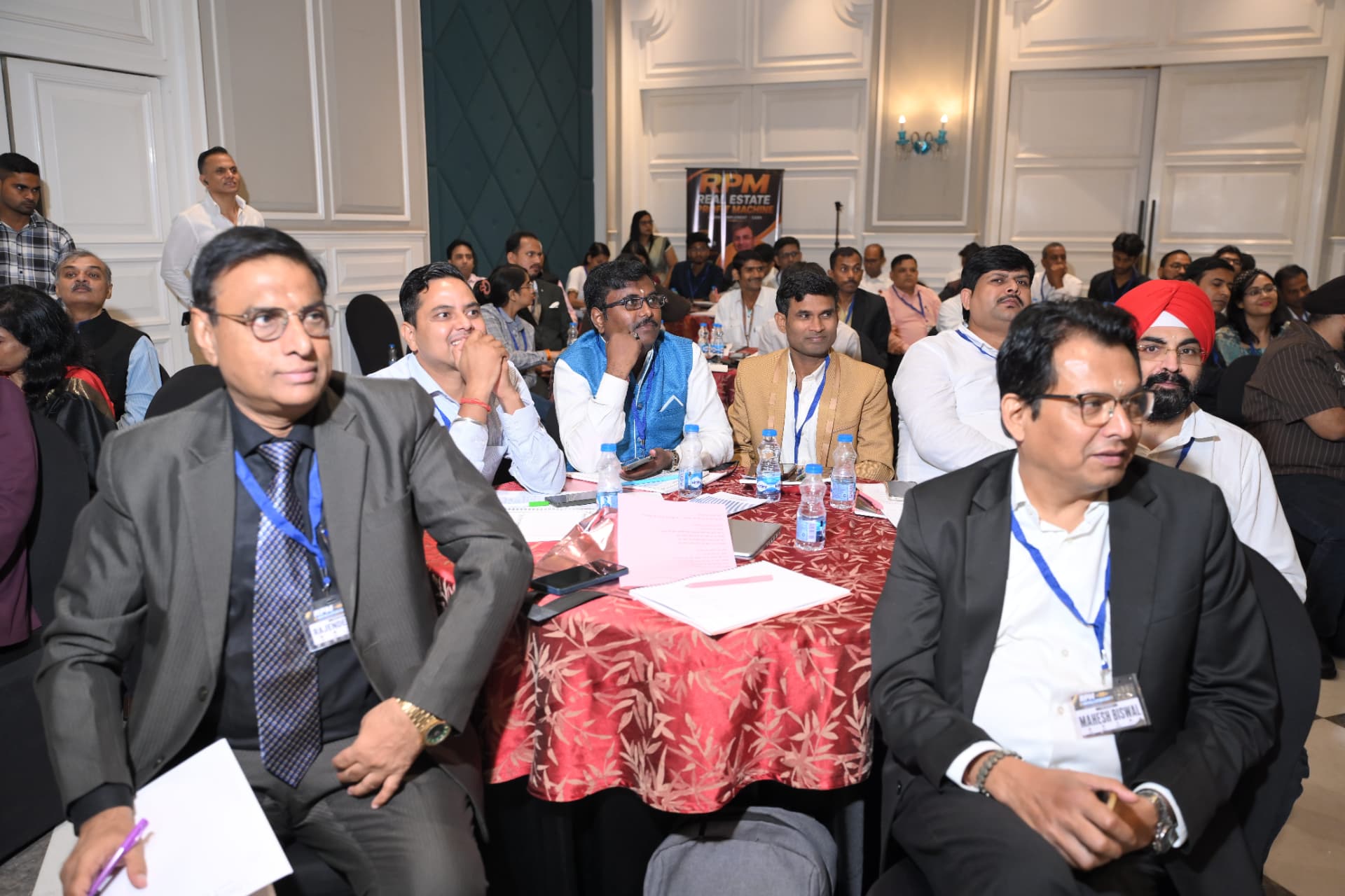 A packed hall of brokers watching the session