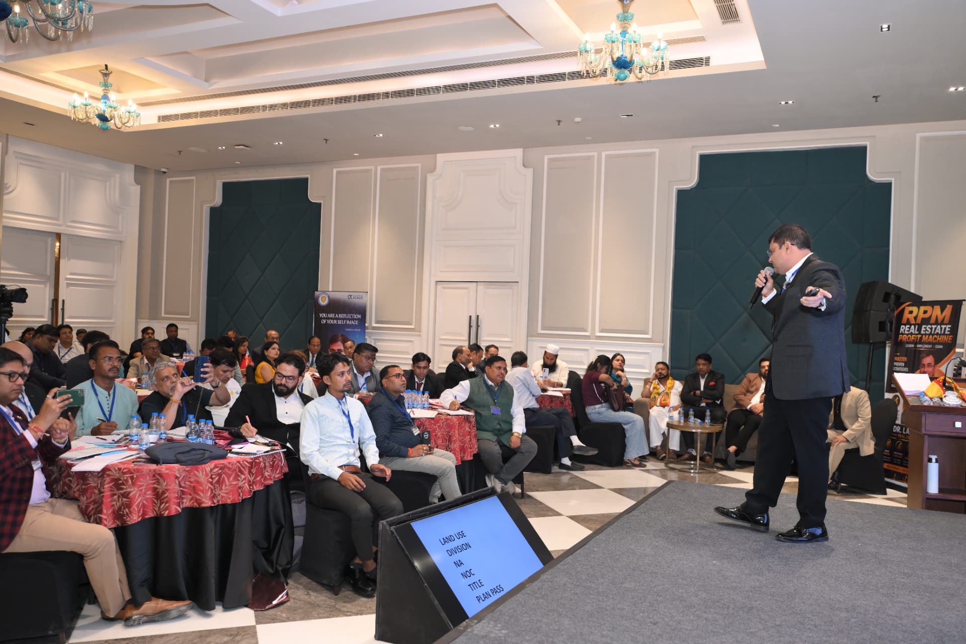Dr. Lalit Arora addressing a full room from the stage at the RPM workshop