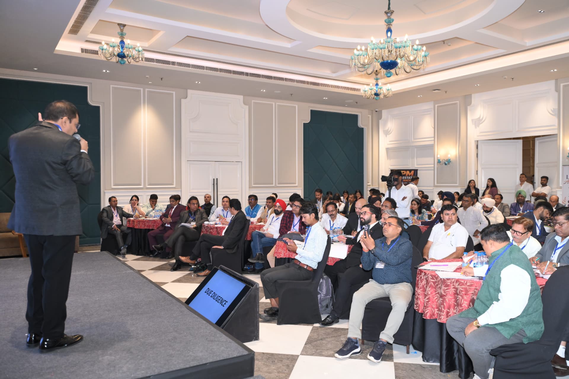A speaker addressing the full room from the stage