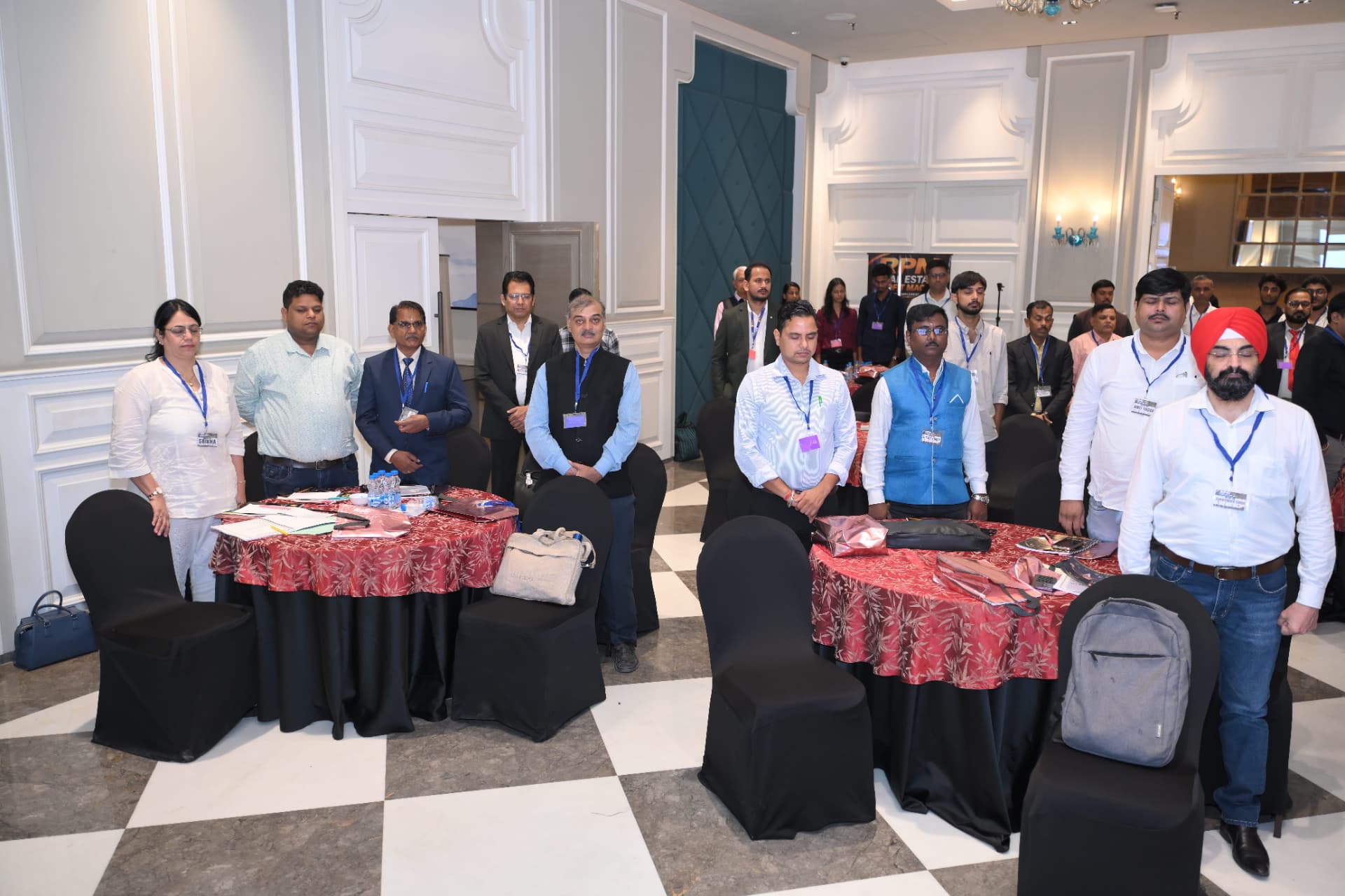 Attendees standing at their tables during the opening