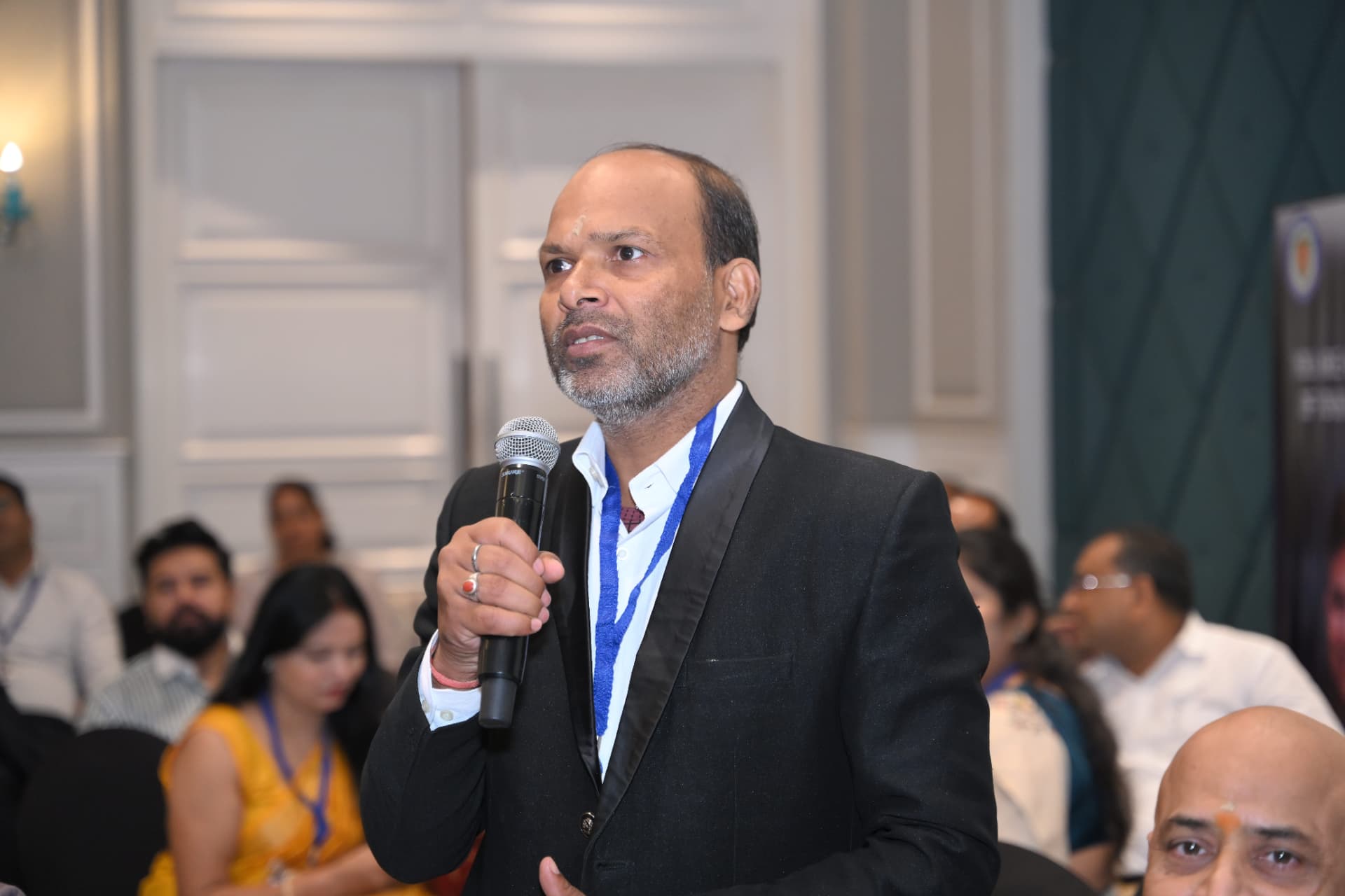 A participant speaking on the microphone to the room