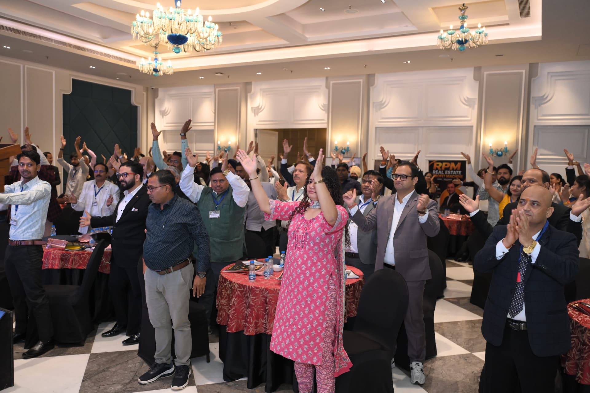 The room standing with hands raised during a live exercise